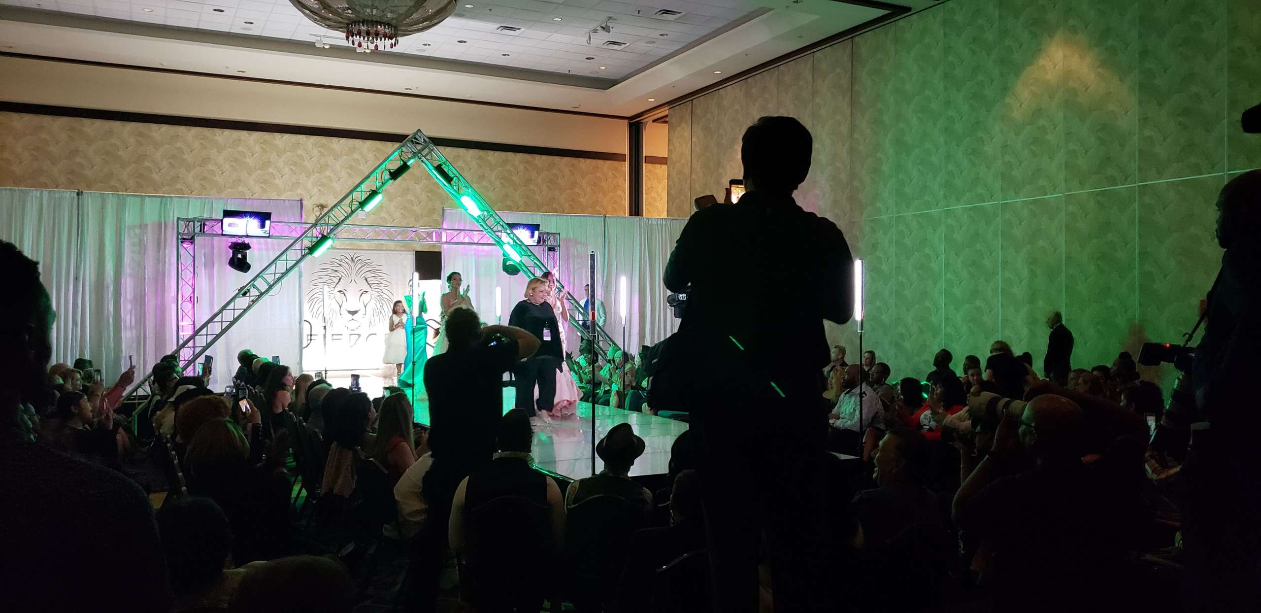 OIFW runway production with stage, audience, and show-day crew in view